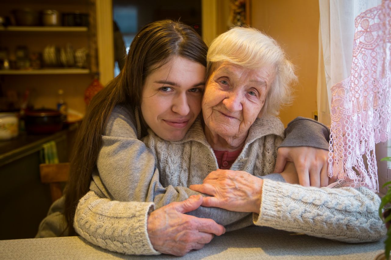 Older woman being hugged by younger woman