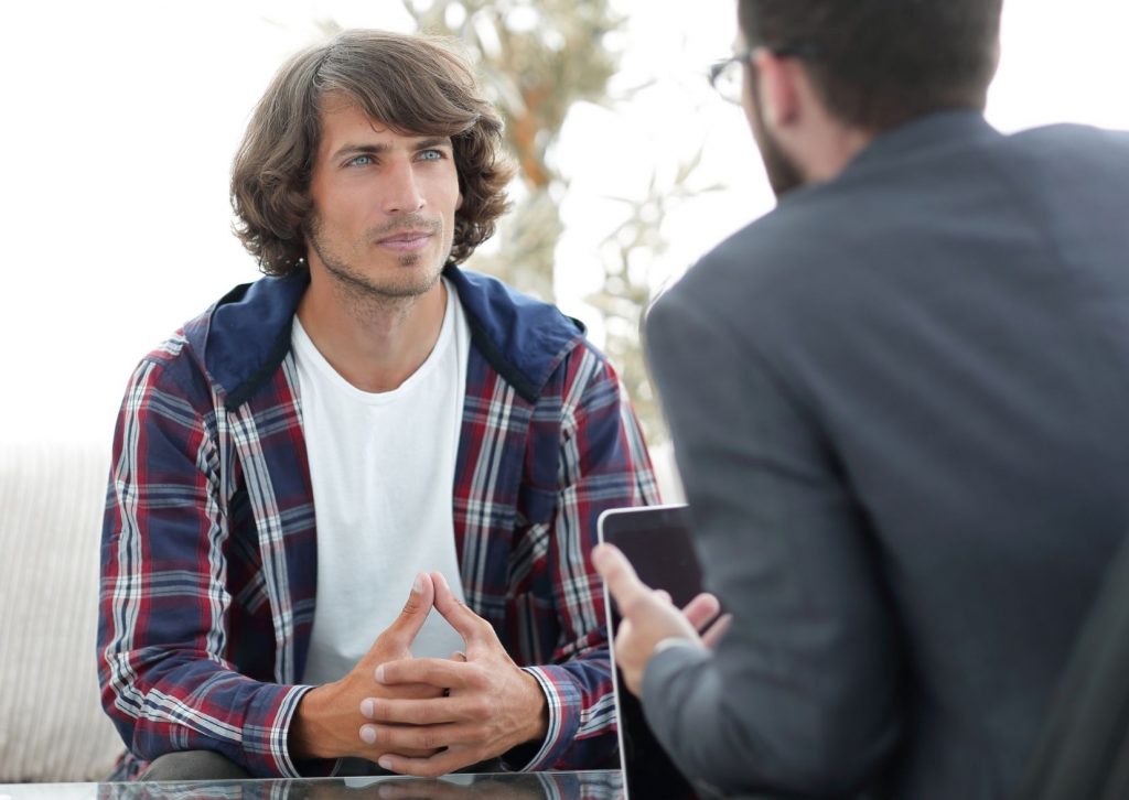 Two men talking. Appears that one is giving advice to another.