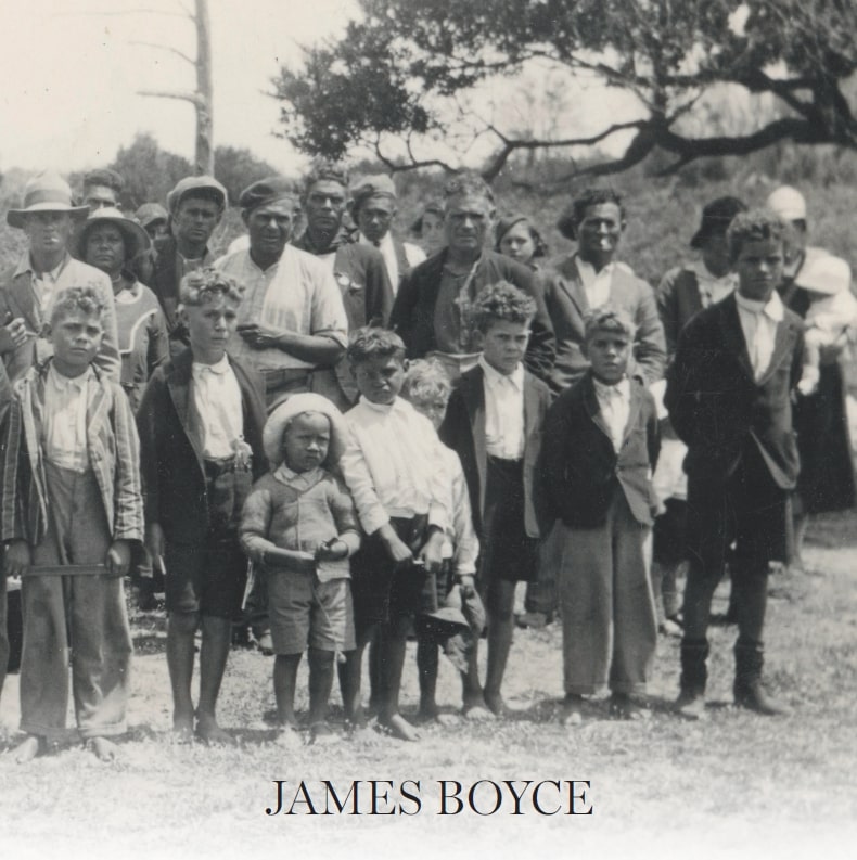 a black and white photograph of aboriginal children dressed in European clothes. There are some adults in the background, some European and aboriginal.