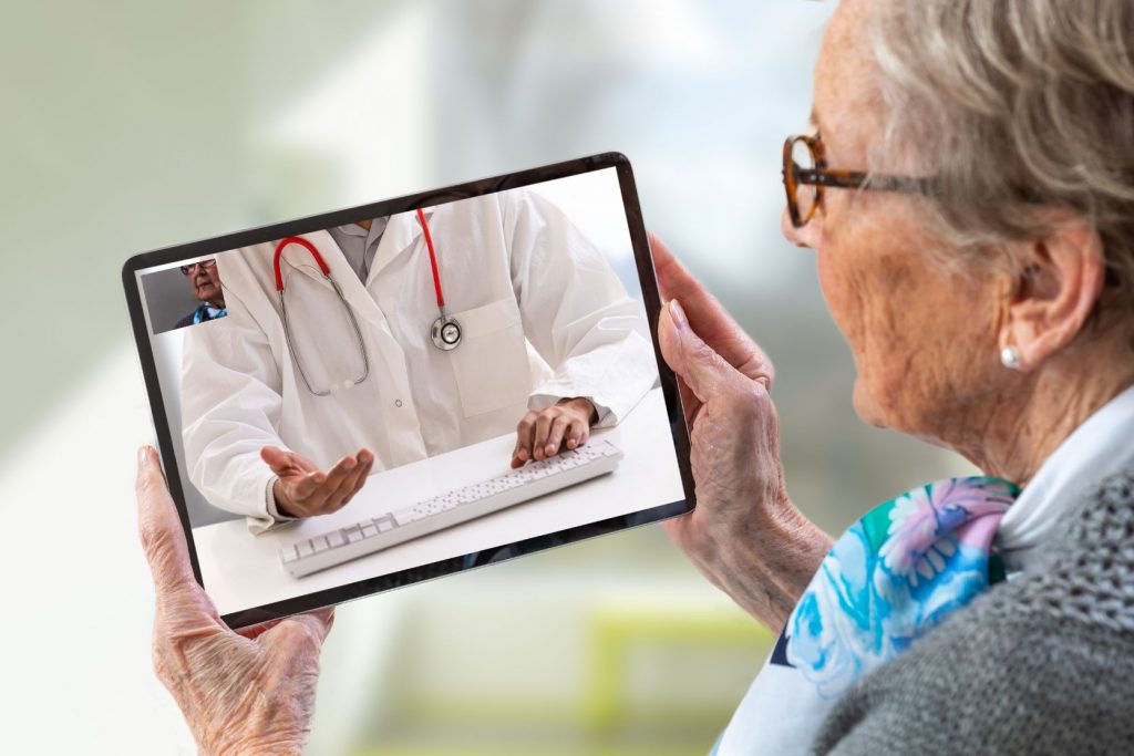 An older woman using telehealth for a doctor's consultation