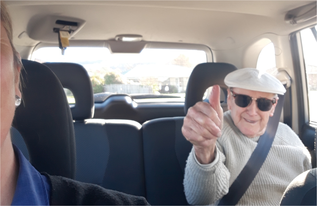 Thumbs up from client in the back seat of home care support workers vehicle