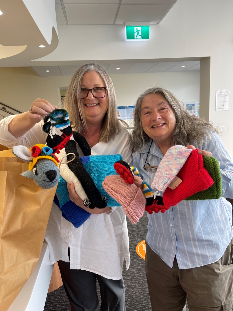 A photo showing some of the knitted items made by the All Saints Network of Anglican Churches in the Launceston area. Toys, booties, beanies, blankets and more!