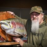 Scotty holding his mounted fish artwork.