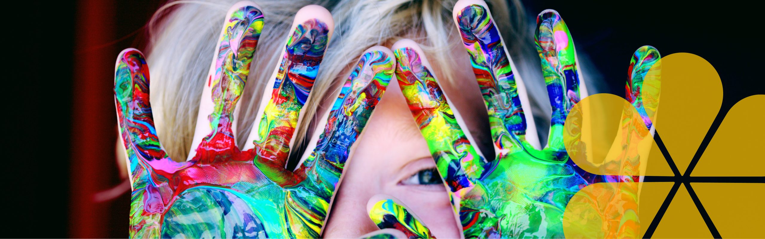 A image of a childs hands with paint all over them like they have been hand painting