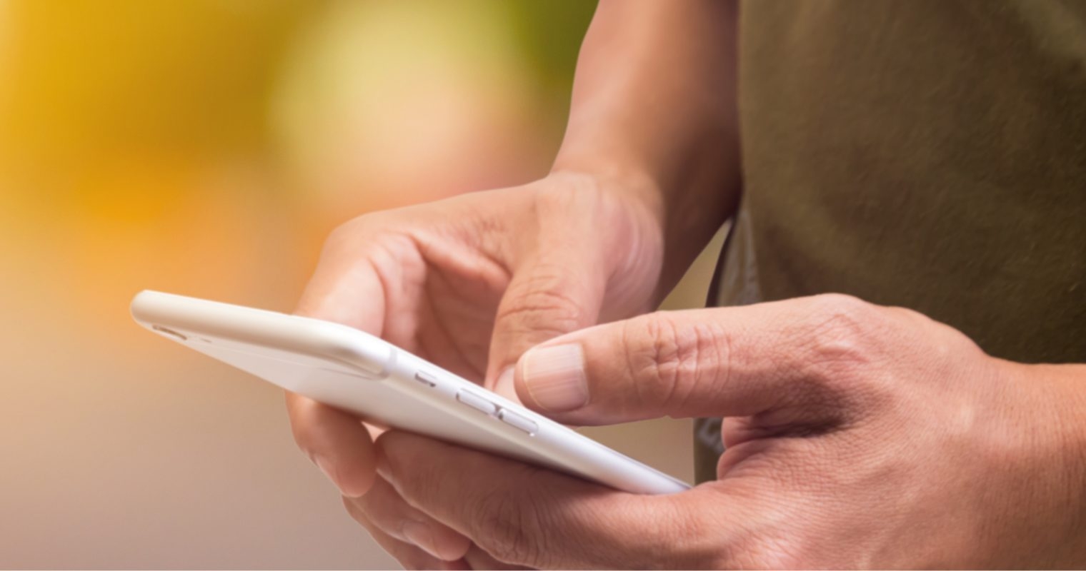 hands holding a phone with fingers tapping on the screen indicating ringing a phone number