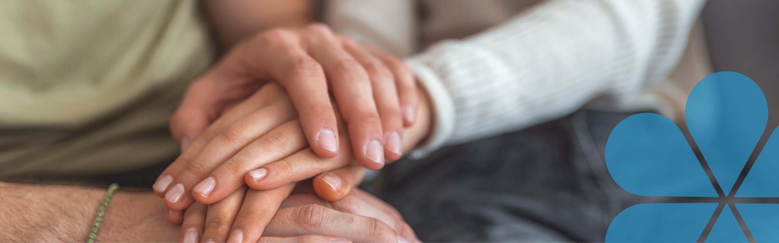 Hands covering another persons hands showing support. The words 'facing life's challenges together'