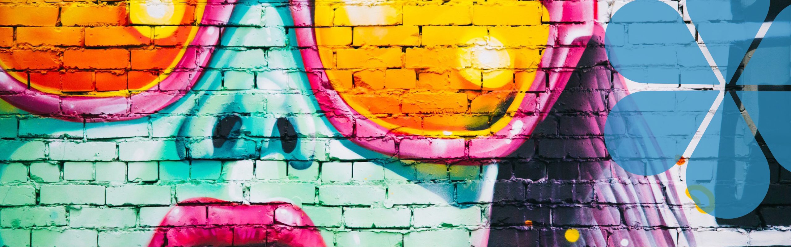 A photo of a wall which has been spray painted. The artwork is of a woman with big red lips and wearing sunglasses.