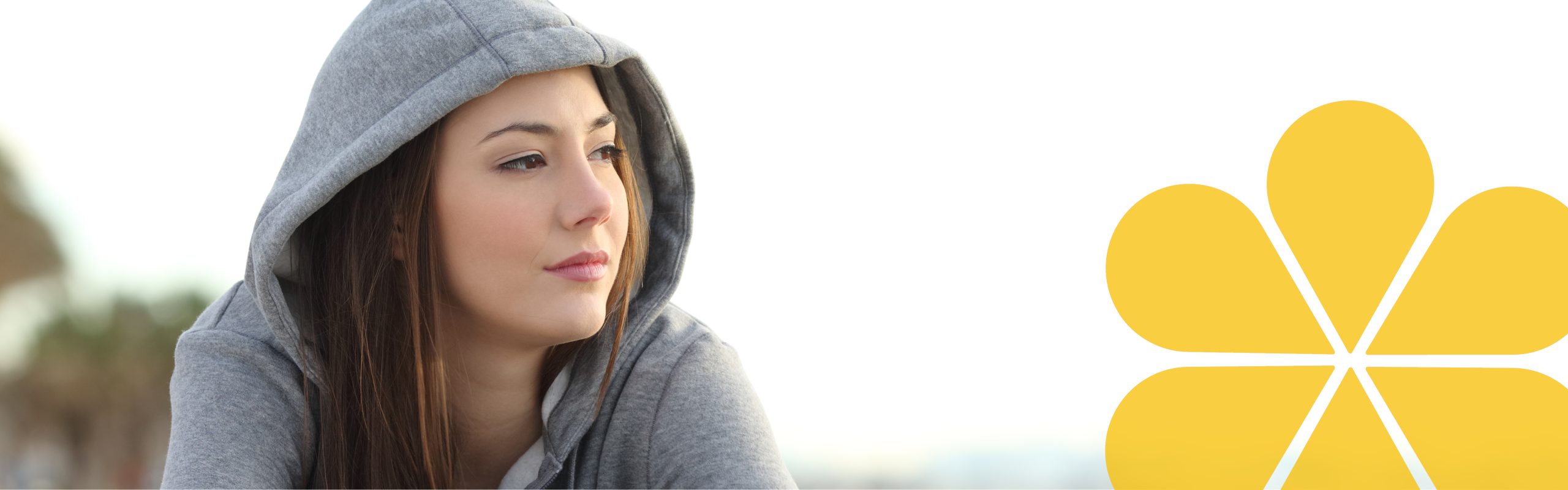 Girl with a hoody on looking into the distance. She looks like she is thinking.