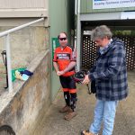 A photo of Mathew with Graham who is helping him to put on his bicycle helmet