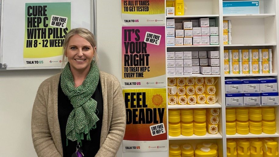 A member of Anglicare's Needle and Syringe Program is pictured in the Burnie outlet. Behind her there are posters with health messages and sterile injecting equipment for people who use drugs.