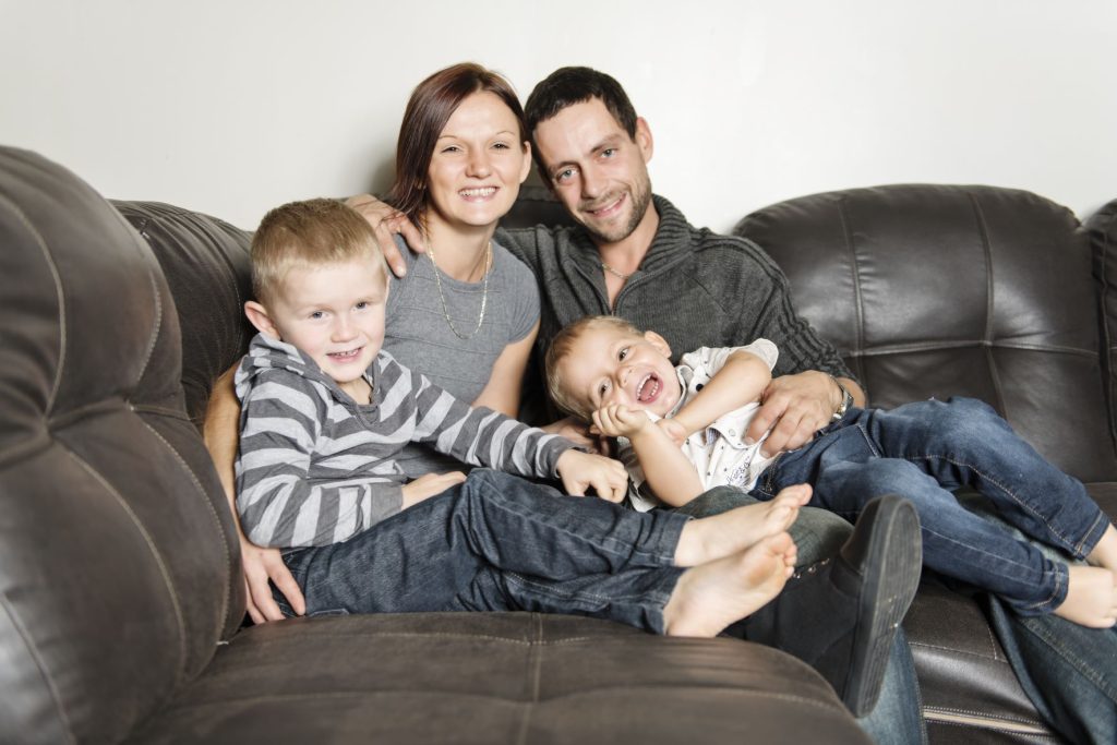 A family relaxes on a couch.