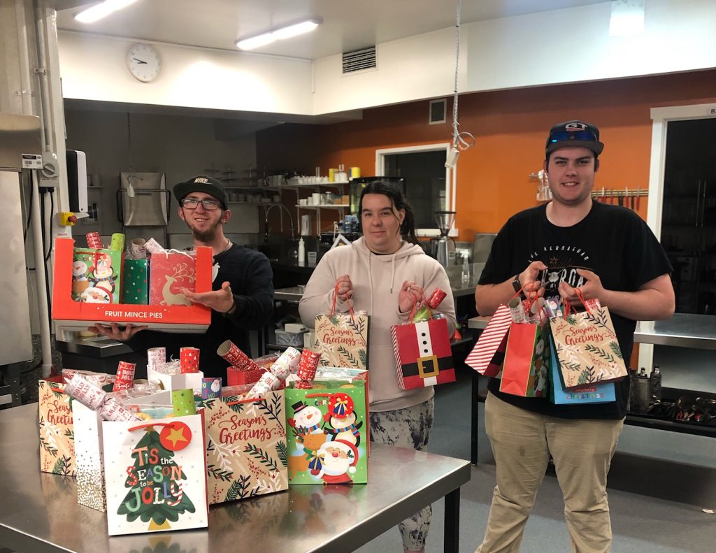 A photo of Eveline house students holding the bags of christmas gifts that they are going to give to homeless people in the Devonport community.