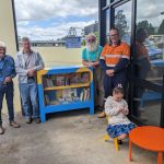 A photo of some people standing around the new street library at the launch.