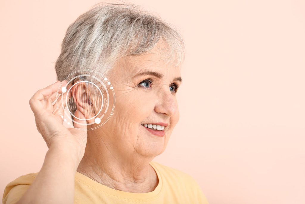 A lady with her hand held behind her ear as if she is trying to hear something.