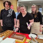 Graduating students are cutting the cake to celebrate