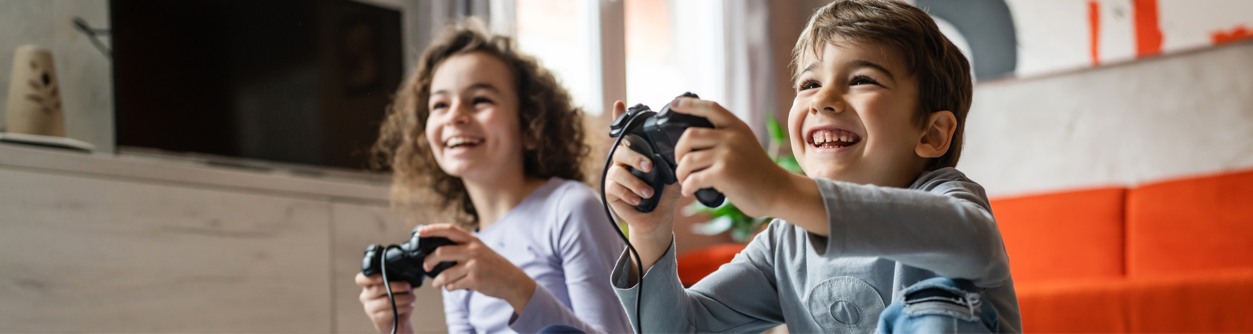 Two children playing video games in their living room.